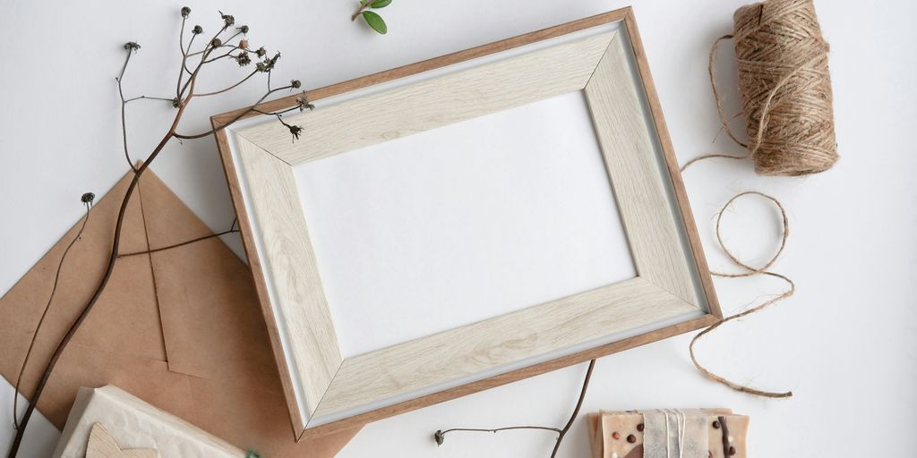 a white picture frame sitting on top of a table next to twine of twin